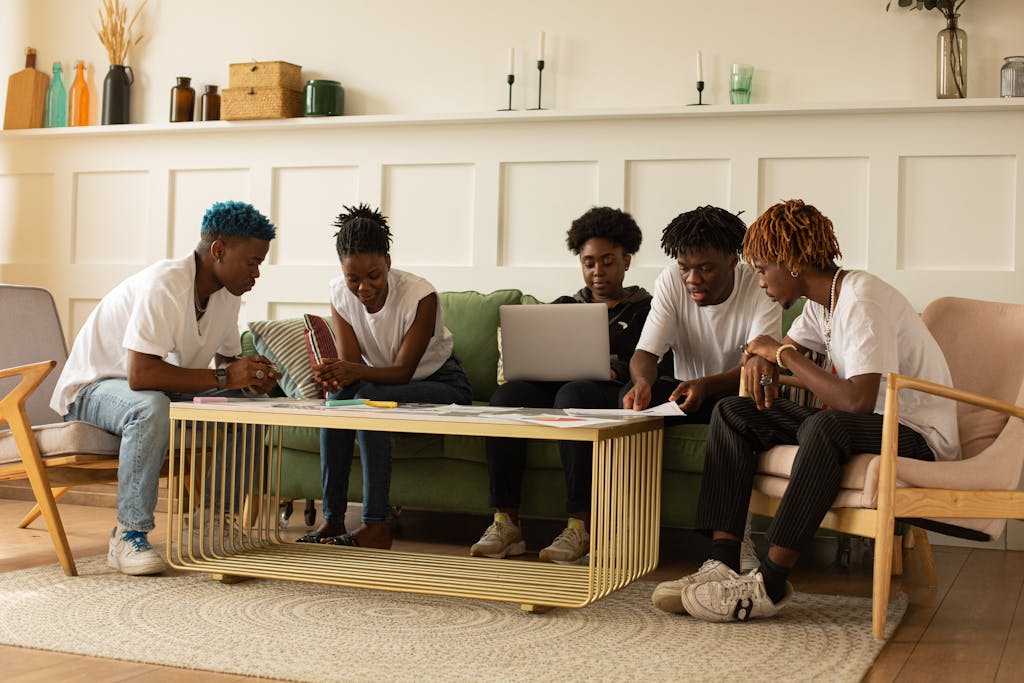 A group of young adults collaborating in a stylish workspace, focusing on teamwork and creativity.