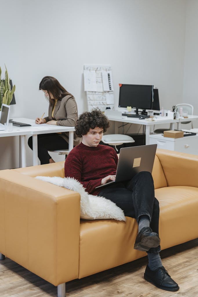 Two colleagues in a modern office setting working intently on projects, highlighting productivity.